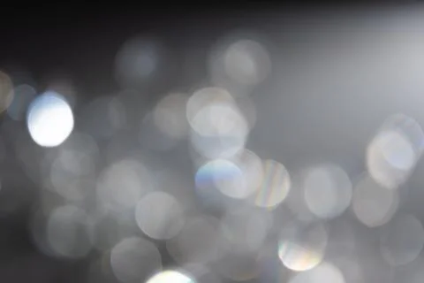 Abstract bokeh effect background in grey colours with rainbow rays. Stock Photos