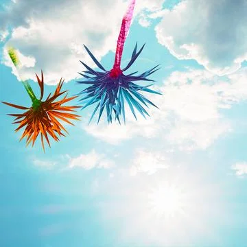 Abstract bright multicolored palms on a background of blue sky with clouds. Stock Photos