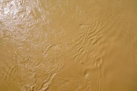 Abstract brown background, pattern. Muddy water, dirty river flow Stock Photos