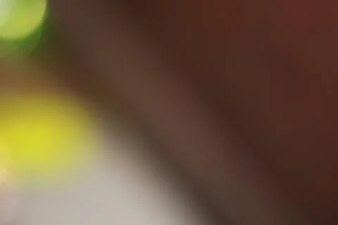 Abstract brown background with soft green and yellow light bokeh circles fo.. Stock Photos