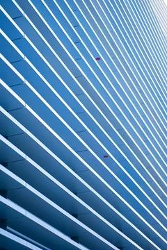 Abstract building exterior rhythmic pattern of blue and white horizontal lines Stock Photos
