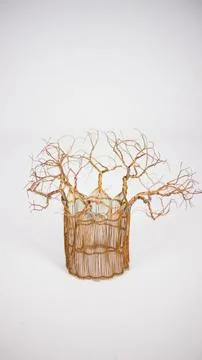 Abstract cage with sharp leafless trees on top of it woven from gold thread on a Illustrazione stock