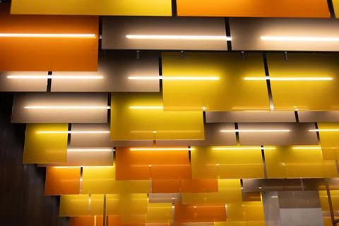 Abstract ceiling panels with warm yellow and orange colors, featuring integrated Stock Photos
