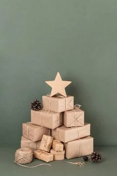 Abstract Christmas tree. Boxes in craft paper, twine, scissors, cones on gree Stock Photos