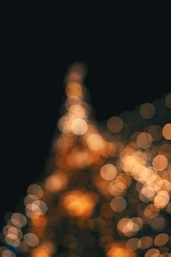 Abstract christmas tree shape created with glowing golden bokeh lights in t.. Stock Photos