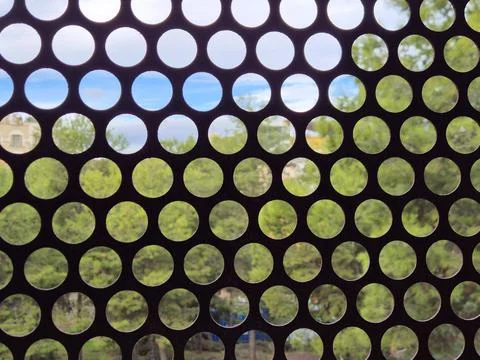 Abstract circular perforated pattern with blurred nature backgro Stock-Fotos