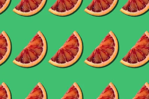 Abstract citrus summer background. pattern of red orange slices on green back Stock Photos