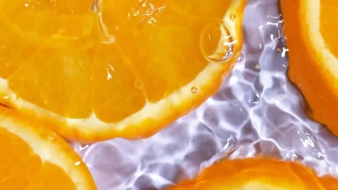 Abstract clean water ripples moving across organic orange slices, overhead view Stock Footage 338397603