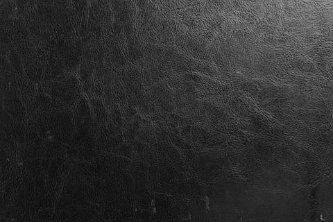 Abstract close-up of aged black leather surface with grunge texture, wrinkles Stock Photos