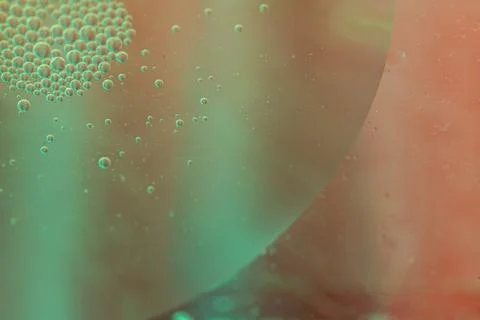 Abstract close-up of bubbles in liquid, showcasing a blend of teal and oran.. Stock Photos