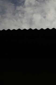 Abstract Cloudscape and a Wavy Dark Silhouette Edge Against the Sky Stock Photos