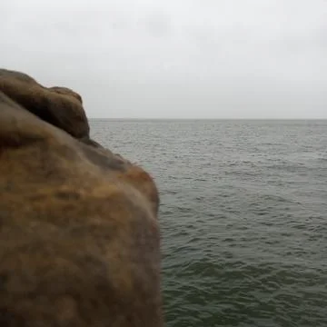 Abstract coastal composition featuring blurred rock edge vast calm ocean Stock Photos