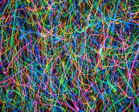 Abstract colored light lines on a black background. Blue, green, orange, pink Stock Illustration