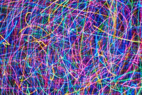 Abstract colored light lines on a black background. Blue, green, orange, pink Stock Photos