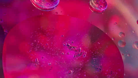 Abstract colorful liquid drops and oil blending with vibrant purple and pink Stock Footage 346321867