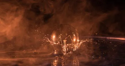 Abstract concept. Light bulb dropping on water or water splash on dark foggy  Stock-Fotos