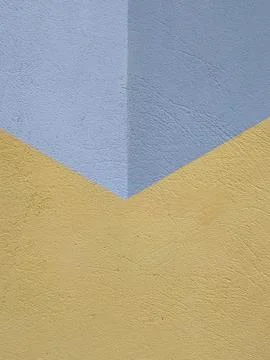 Abstract corner intersection of blue and yellow textured architectural walls Stock Photos