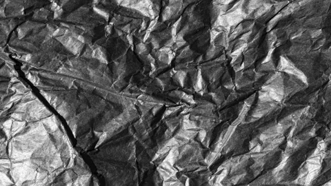 Abstract crumpled black paper texture video loop background in 4k ultra hd Stock Footage 346689046