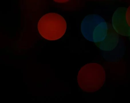 Abstract dark background with assorted coloured light circles with copyspace Stock Photos