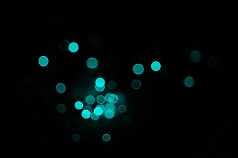 Abstract dark background with glowing turquoise light circles and soft blur.. Stock Photos