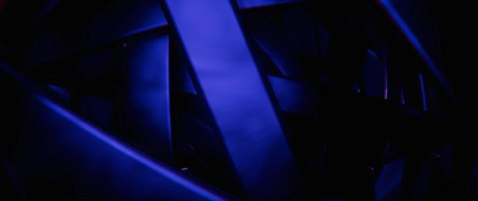 Abstract dark background with intersecting geometric shapes illuminated by .. Foto stock
