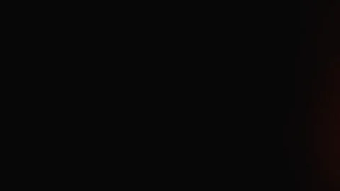 Abstract dark background with a subtle orange light flare on the left side 库存影片 341041971