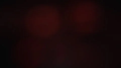 Abstract dark background with subtle red light bokeh effect, creating a Stock Footage 340925439