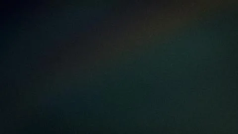 Abstract dark gradient background with green yellow and blue tones 4K grain.. Stock Photos