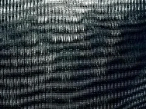 Abstract dark mesh screen overlaying eerie foggy silhouette evoking mysteriou Stock-Fotos