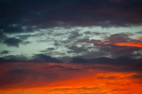 Abstract dark red background. Dramatic fiery bloody sky. Fantastic golden sun Stock Photos