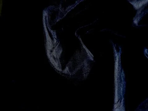 Abstract dark textured surface with subtle blue highlights and deep shadows. Stock Photos