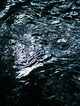 Abstract Dark Water Surface with Light Reflections and Ripples - Mysterious.. Фото
