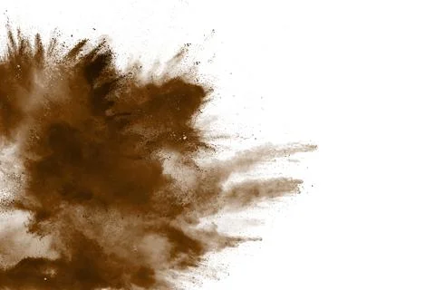 Abstract deep brown dust explosion on white background. Freeze motion of co.. Stock Photos