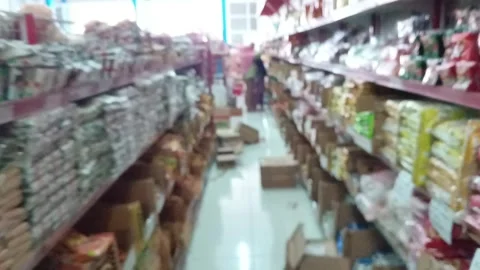 Abstract, defocused background of a brightly lit supermarket aisle with customer Stock Footage 318599294