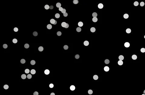 Abstract defocused white light circles scattered across black background. Stock Illustration
