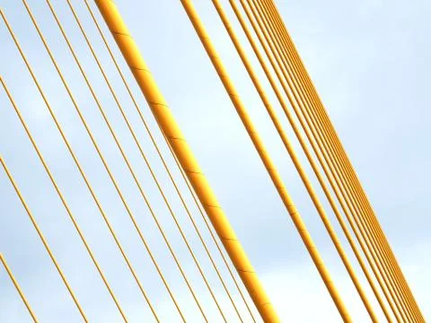 Abstract diagonal two row of yellow suspension bridge cable, with blue sky Foto stock