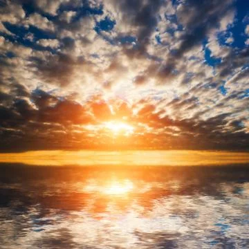 Abstract, dramatic sunset at the sea, ocean. sun and clouds reflection in wat Stock-Fotos