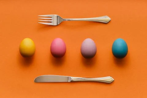 Abstract Easter background with colorful eggs in row with fork and knife 스톡 사진