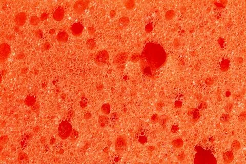 Abstract embossed orange background - the surface of a soft sanitary sponge Stock Photos