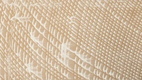 Abstract embossed rough stone background in beige color with white spots Stock Photos