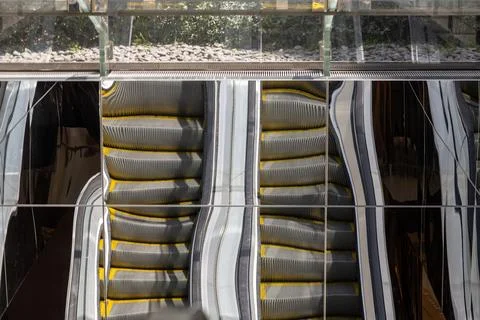 Abstract escalator reflection on mirrores building facade Stock Photos