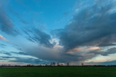 Abstract evening cloud over a green field Stock Photos