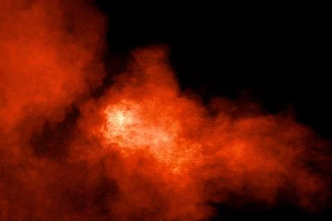 Abstract explosion of orange dust on black background.Freeze motion of oran.. Stock Photos