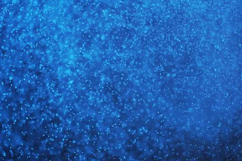 Abstract festive background with selective focus. Bright blue particles on dark Illustrazione stock