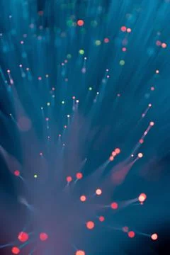 Abstract fiber optic light explosion with colorful bokeh dots on dark teal Fotos de archivo