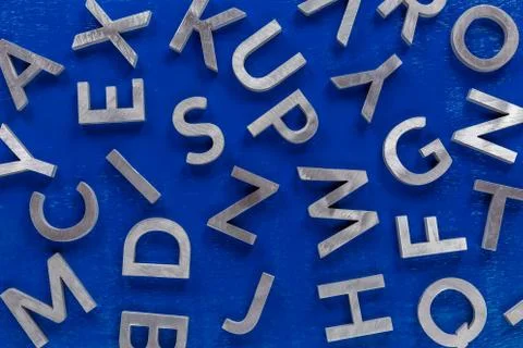 Abstract flat background of silver metal english alphabet characters on blue Stock Photos