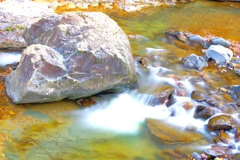 Abstract Flow: Long Exposure of River Water Around Boulders Stock-Fotos
