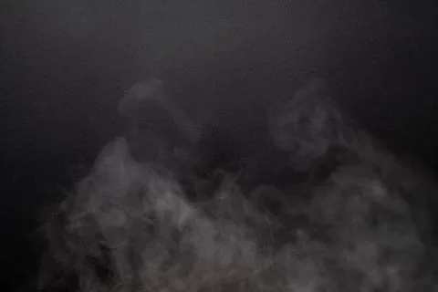 The abstract flow of smoke from a black background. Stock Photos