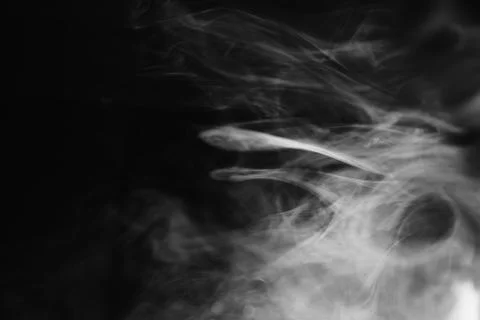 Abstract flowing white smoke patterns swirling against a dark background fo.. Stock Photos