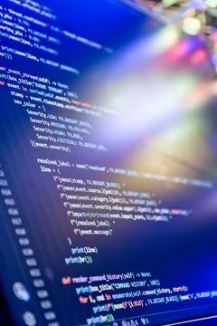 Abstract futuristic programming code on computer screen. Macro shot of a dark Stock Photos